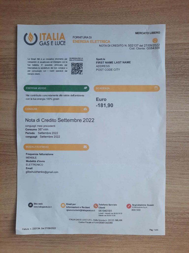 Official-looking Gas Italia E Luce Electricity utility bill shown on wood surface