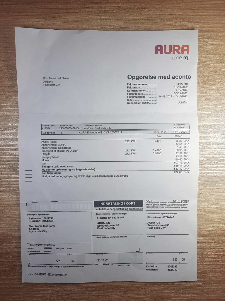 AURA ENERGI customer bill from Denmark displayed on desk